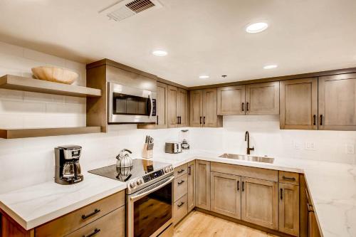 Una cocina con gabinetes de madera y electrodomésticos de acero inoxidable. en PARK STATION 213-1 condo, en Park City
