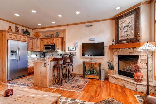 a kitchen with a bar with a fireplace and a tv at LIFT LODGE 203 condo in Park City