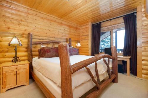 a bedroom with a bed in a log cabin at COMSTOCK 205 condo in Park City