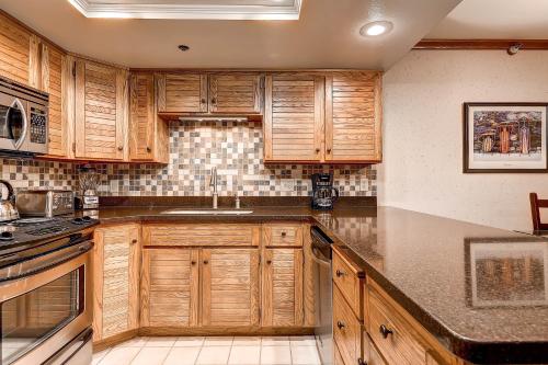 a kitchen with wooden cabinets and a sink at PARK STATION 247-1 condo in Park City