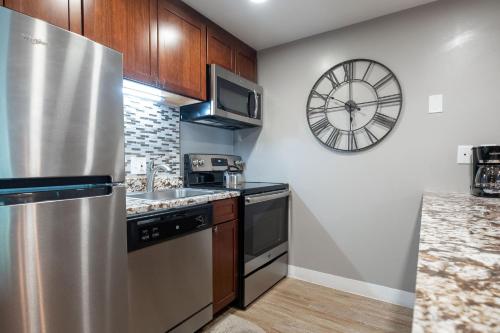 a kitchen with a stainless steel refrigerator and a clock at EDELWEISS HAUS 117 condo in Park City