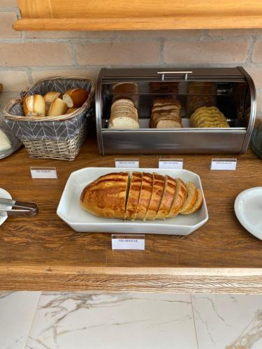 a table with a plate of food and pastries at Pousada Alpes Azul in Campos do Jordão