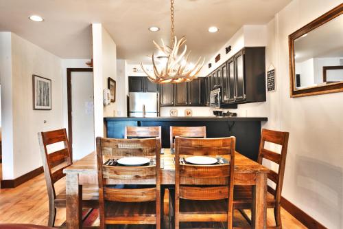 una cucina e una sala da pranzo con tavolo e sedie in legno di SNOW FLOWER 104 condo a Park City
