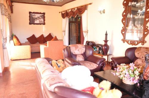 a living room with leather chairs and a couch at Ragith Villa in Nuwara Eliya