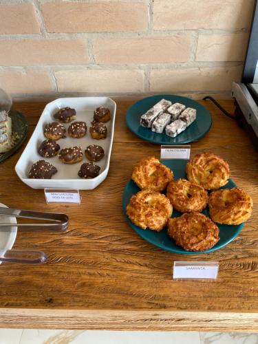 a table with two plates of donuts and a tray of cookies at Pousada Alpes Azul in Campos do Jordão