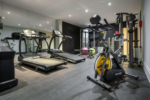 - une salle de sport avec plusieurs tapis de course et vélos d'exercice dans l'établissement Radisson RED Brussels, à Bruxelles