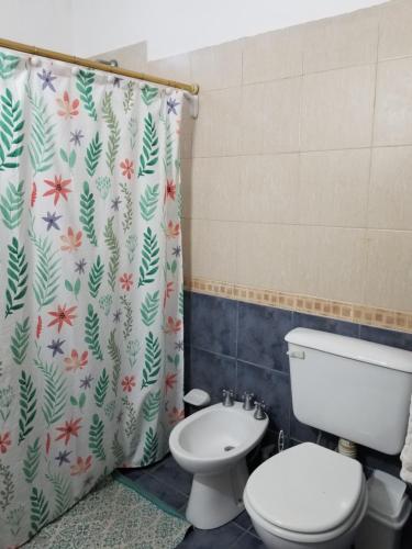 a bathroom with a toilet and a shower curtain at La Soñadita in Salta