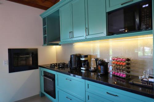 a kitchen with blue cabinets and a black counter top at Parador São João in Canela
