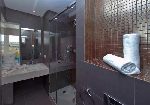 a bathroom with a glass shower and a sink at Relax Hôtel Oujda in Oujda