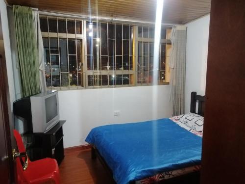 a bedroom with a bed and a tv and a window at Preludio in Tunja