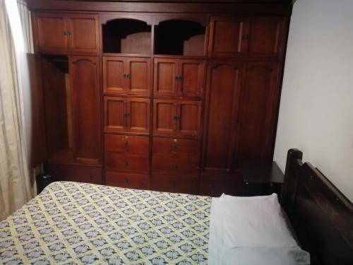 a bedroom with a bed and a wooden cabinet at Preludio in Tunja