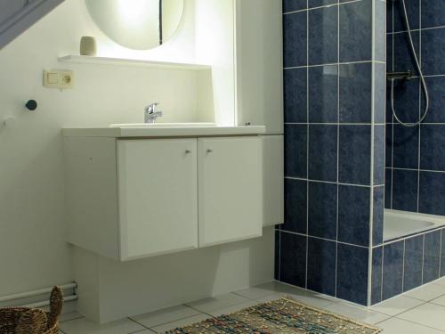 a bathroom with a white sink and a shower at Retreat near Maasmechelen in Lanaken