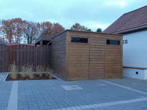 a large wooden garage next to a fence at Retreat near Maasmechelen in Lanaken