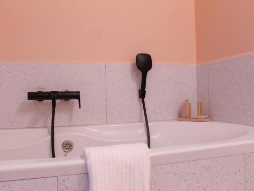 a bathroom with a bath tub with a blow dryer at Retreat near Maasmechelen in Lanaken