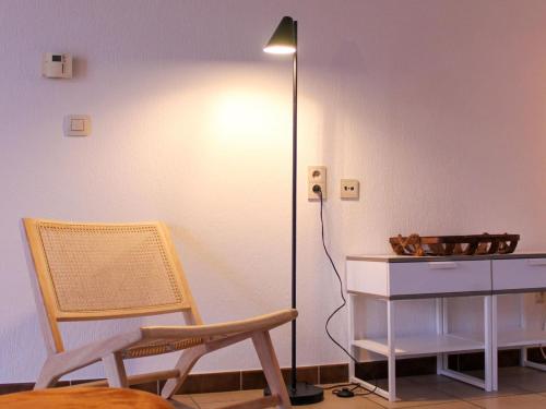 a room with a chair and a lamp and a desk at Retreat near Maasmechelen in Lanaken