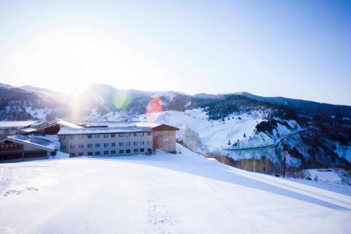 a building on top of a snow covered mountain at Manza Prince Hotel in Tsumagoi