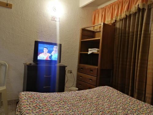 1 dormitorio con 1 cama, TV y vestidor en Preludio en Tunja
