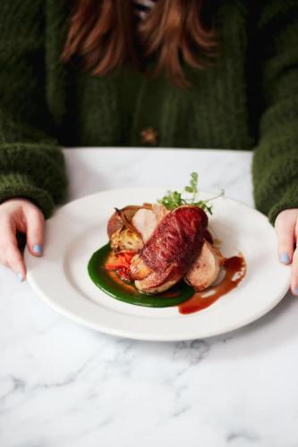 a person sitting at a table with a plate of food at The Five Dials Inn in Ilminster