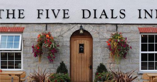 a building with a sign that reads the five dials inn at The Five Dials Inn in Ilminster