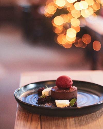 a black plate with a dessert on a table at The Five Dials Inn in Ilminster