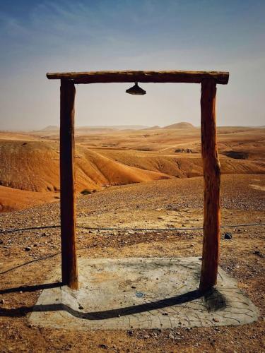 a wooden table in the middle of the desert at Alkamar Camp Agafay in El Karia