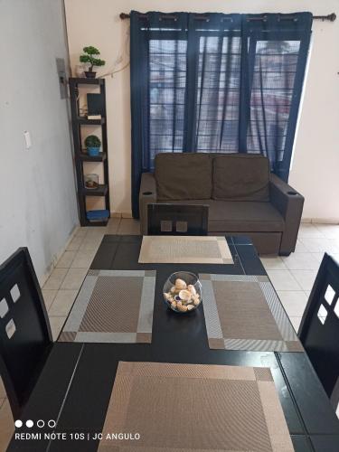 a living room with a couch and a table at Depa sencillo, 10 min malecon in Mazatlán