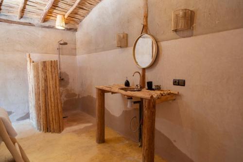 La salle de bains est pourvue d'un lavabo et d'un miroir mural. dans l'établissement Alkamar Camp Agafay, à El Karia