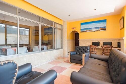 a living room with a couch and chairs and a table at Hotel Rivera Del Mar in Barranquilla