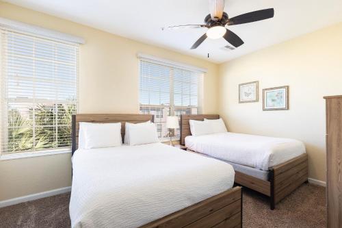a bedroom with two beds and a ceiling fan at Orlando Resort Rentals at Universal Boulevard in Orlando