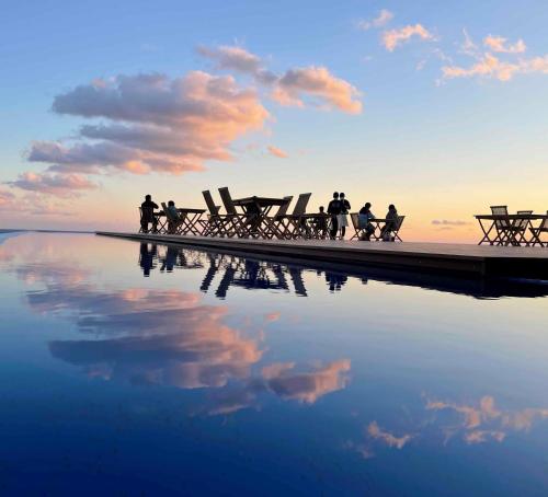 a group of people sitting at a picnic table on a dock at TheMana Village in Tosashimizu