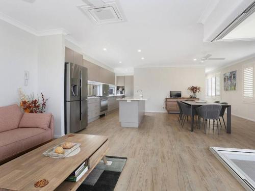 a living room and kitchen with a couch and a table at The White House Yamba in Yamba