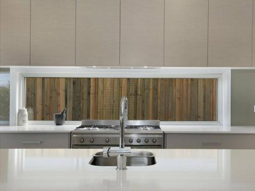 a kitchen with a stove and a sink in it at The White House Yamba in Yamba