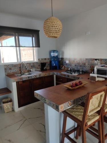 una cocina con una barra con un bol de fruta. en Casa las Galias. en Tlalixtac de Cabrera