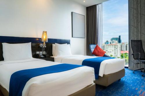 two beds in a hotel room with a window at Holiday Inn Express Bangkok Siam, an IHG Hotel in Bangkok