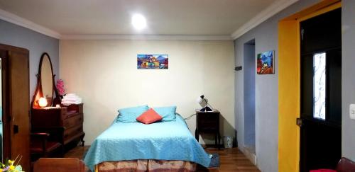 a bedroom with a bed with a blue comforter at Xelanos in Quetzaltenango