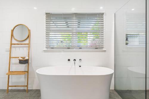 a white bath tub in a bathroom with a window at Longley Place in Alfredton