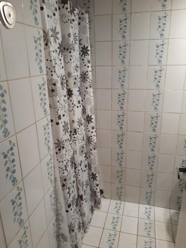 baño con cortina de ducha y suelo de baldosa. en Departamento PLAYERO en Mar del Plata