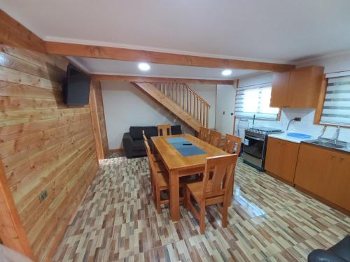 una cucina e una sala da pranzo con tavolo e sedie in legno di cabaña los robles a Licán Ray