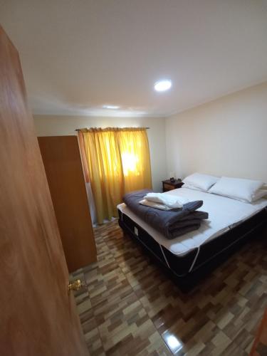 a bedroom with a bed and a wooden floor at Cabañas Mulpun in Licán Ray