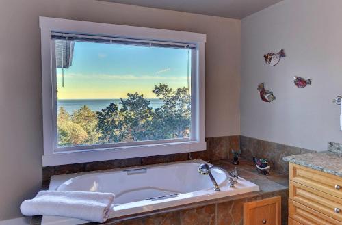 a bath tub in a bathroom with a large window at Arbutus Hill in Victoria