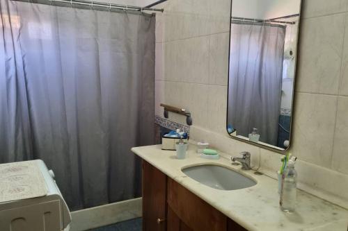 a bathroom with a sink and a shower curtain at Colinas in Ciudad de la Costa