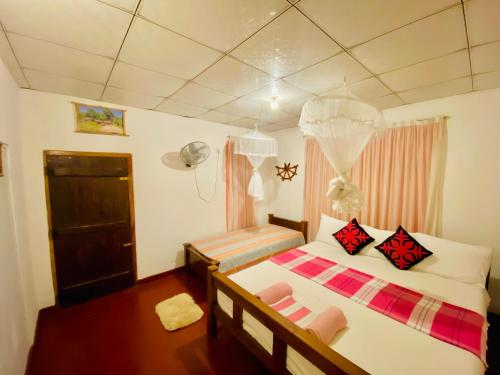 1 Schlafzimmer mit 2 Betten und einem Ventilator in der Unterkunft Sheran Safari House in Udawalawe