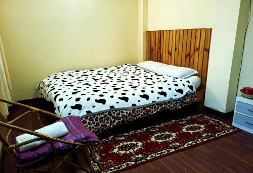 a bedroom with a bed with a black and white comforter at Nirvana Kuti in Kathmandu