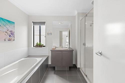 a bathroom with a tub and a sink at Chifley Place - Cool Suburban Crib! in Sebastopol