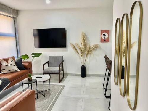 a living room with a couch and a tv at DEPA BOHO AL SUR Pet Friendly Piscina Gym Sala de Cine in Guadalajara