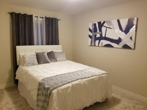 1 dormitorio con 1 cama y una pintura en la pared en Enchanting Niagara Escape, en Welland