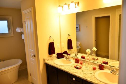 baño con 2 lavabos y espejo grande en Enchanting Niagara Escape, en Welland