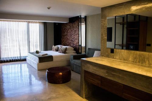 a hotel room with a bed and a living room at Well Hotel & Spa in Maceira
