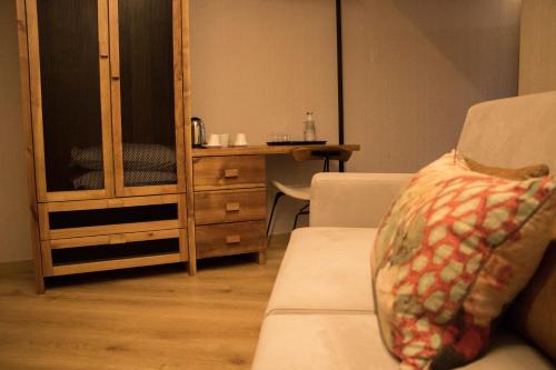 a living room with a couch and a wooden cabinet at Well Hotel & Spa in Maceira