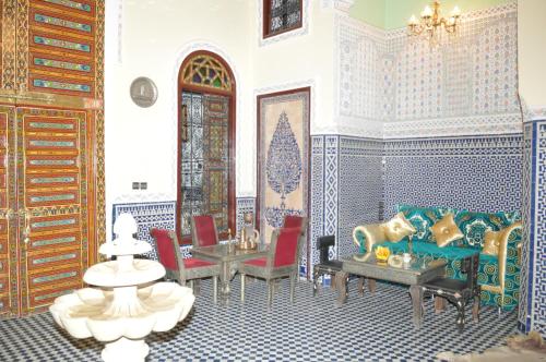 a living room with blue and white tiled walls at Riad Khouloud in Fès